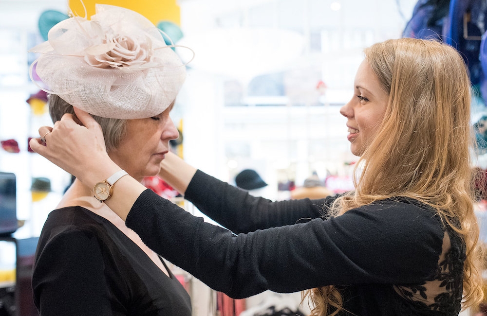 Beverley Edmondson fitting a hat on a millinery client.